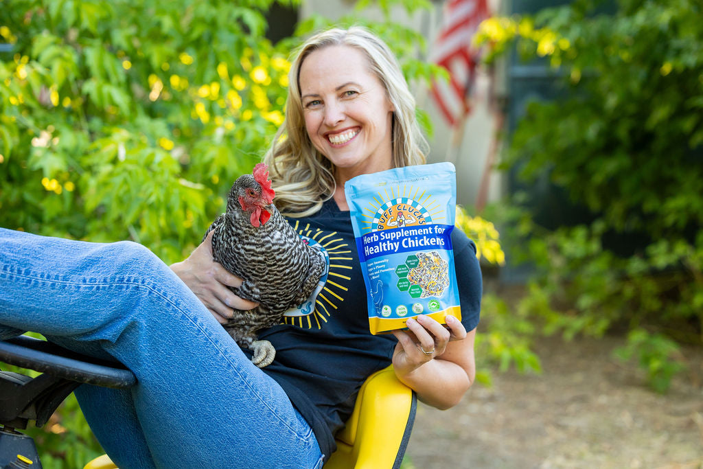 woman holding barred rock chicken on john deer with buff clucks herb supplement for chickens