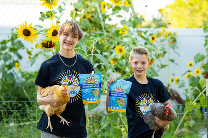 two boys holding chickens and buff clucks herb supplement